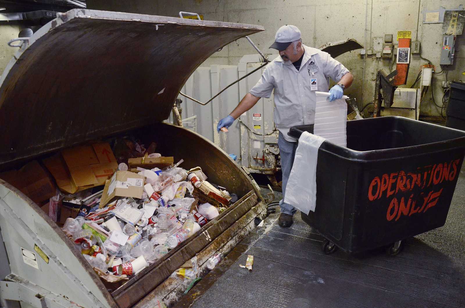 Agustin Cazares, who has been working at SF State for 33 years, empties the compost, recycling and waste beneath the Cesar Chavez Student Center in a zero waste effort on Tuesday, Sept. 3, 2013. Photo by Virginia Tieman / Xpress