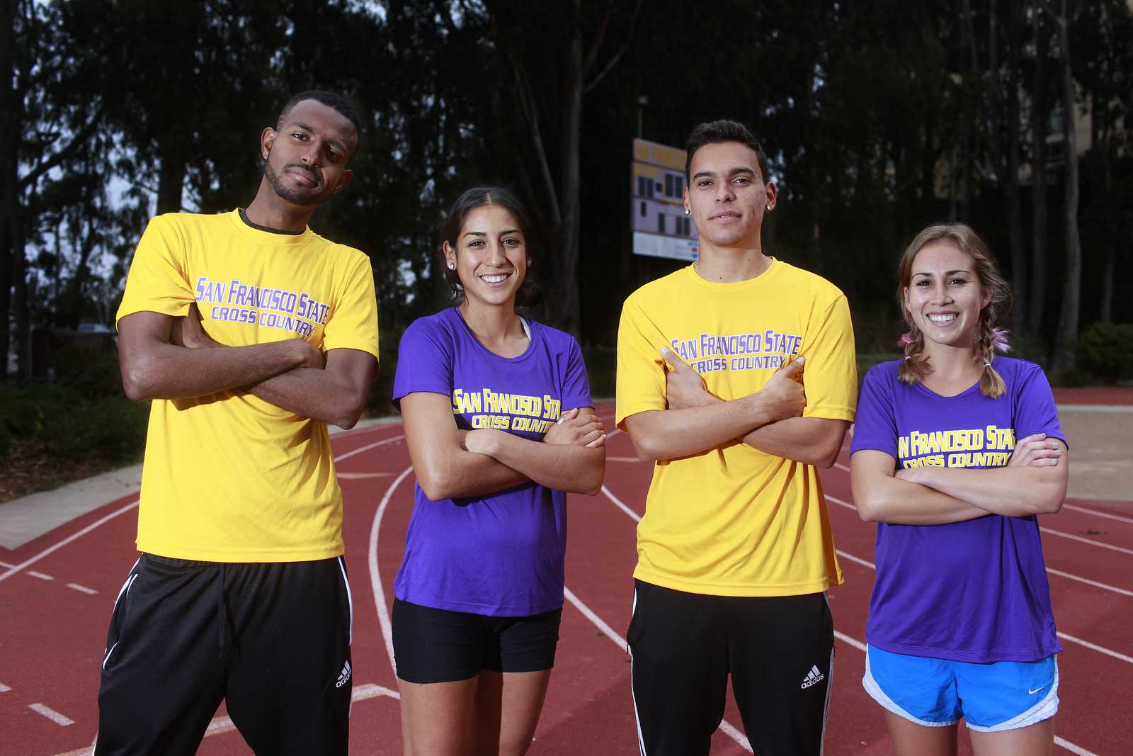 (Left to right) Bruk Assefa, Zuleima Bernal, Benji Preciado and Paxton Cota pose for a portrait in Cox Stadium at SF State on Oct. 21 before a practice run. They're the top ranked runners from SF State going in to the CCAA Championships on Oct. 26. Photo by Mike Hendrickson / Xpress