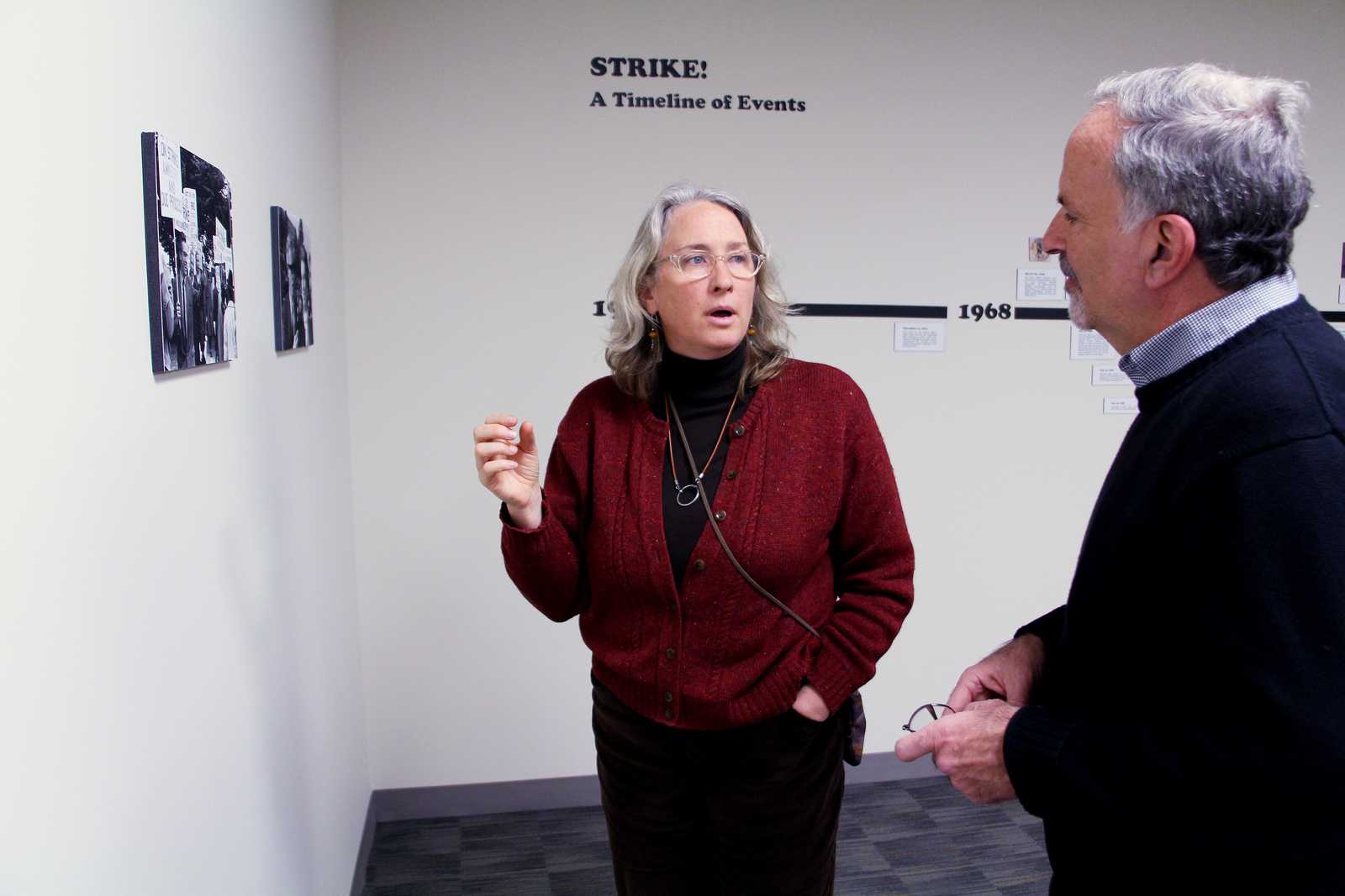 Catherine Powell (left), Director of Labor Archives and Research Center at SF State, talks to Steve Leiken, a History Lecturer at SF State, about the 1968 student strike at SF State, in the Special Collections Section of J. Paul Leonard Library on the 4th floor, Tuesday, Dec. 3rd, 2013. The exhibit features photographs from Phiz Mezey, a former faculty member who was fired after not signing a loyalty oath during the '50s, and came back during the strike to take photos. Photo by Gavin McIntyre / Xpress