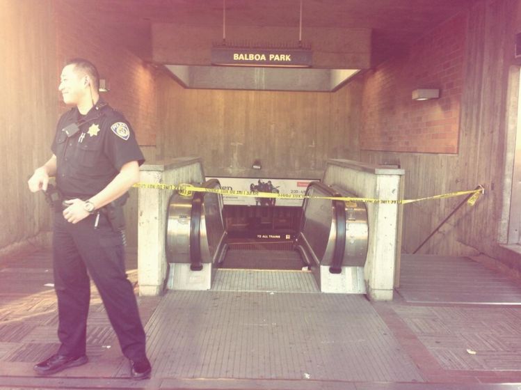 Police Officer S. Jung stands in front of a Balboa BART entrance that is blocked due to a possibly fatal accident on the tracks. 