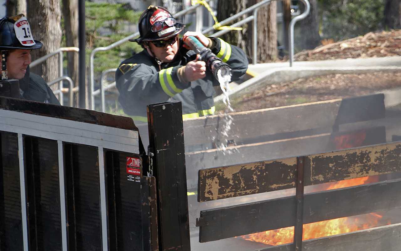 A firefighter puts out flames in the back of a maintenance vehicle next to SF States Student Services building Wednesday, April 2. Photo by Gavin McIntyre / Xpress
