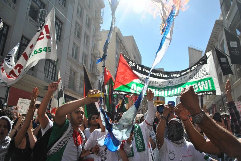 "Free Palestine" supporters burn Israeli flags on Market Street Saturday, July 26, in San Francisco.
