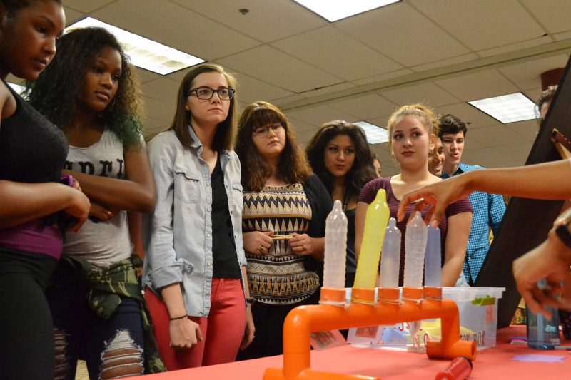 Thursday, Sept. 25, 2014, freshman check out a display showing various condom styles and shapes at the Residential Life Sexpo, an event held by dorm the RAs to help educate incoming students on issues relating to sexuality. Helen Tinna / Xpress.