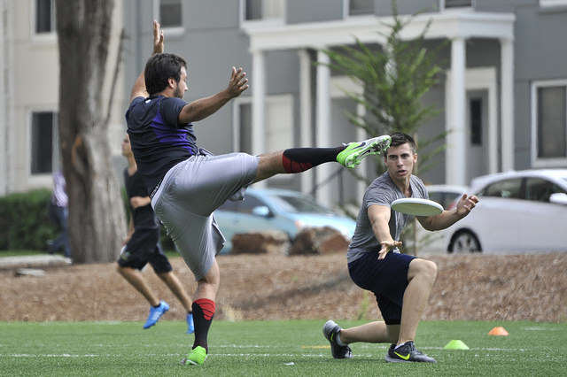 Jacob Hsieh, 22, extends his leg to try and block Tori Suarez's throw during Ultimate Frisbee Club practice on the West Campus Green on Friday, Sept. 12, 2014. Sara Gobets / Xpress.