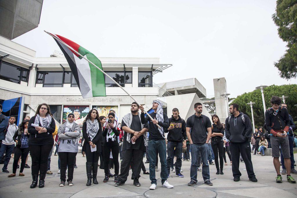 Supporters and members of SF States General Union of Palestine Students, as well as general onlookers, listen to speakers during a gathering to remember the Sabra and Shatila massacre in Malcom X Plaza Tuesday, Sept. 30, 2014.