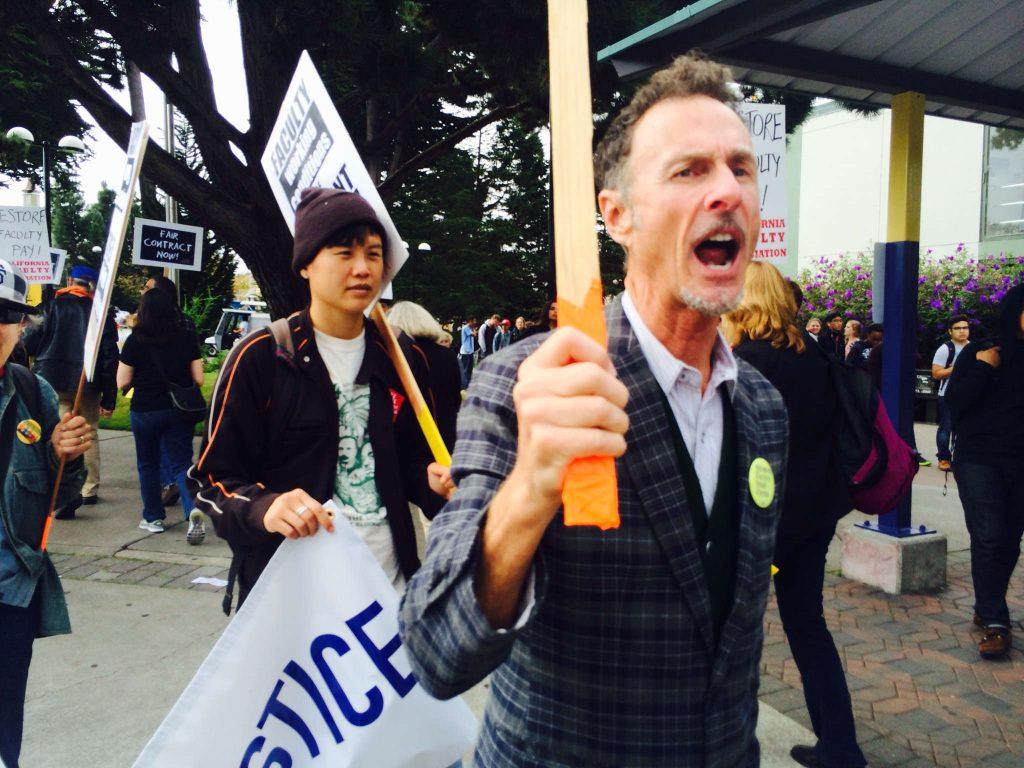 Michael Ritter marches and chants in a picket line in front of SF State Tuesday, Oct. 7, 2014. Students and faculty members gathered at the corner of 19th and Holloway avenues occupying part of the campus entrance.