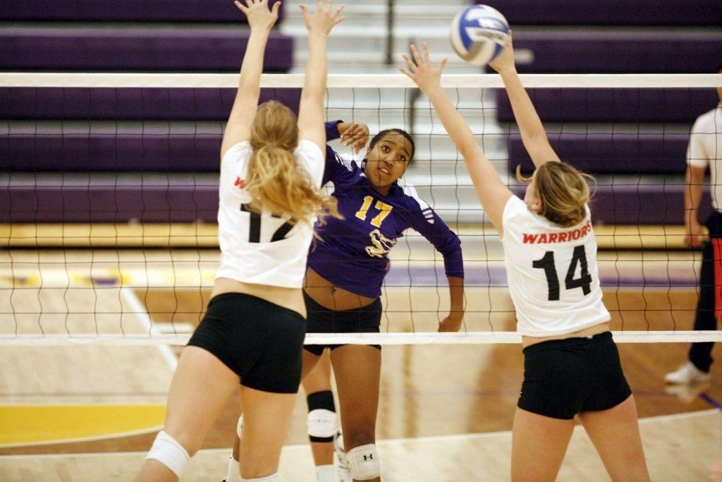 Kaileen Mejia (17) of the SF State Gators spikes the ball through Cal State Stanislaus Warrior blockers Saturday, Oct. 11, 2014. The Gators lost the match 0-3. Martin Bustamante / Xpress.