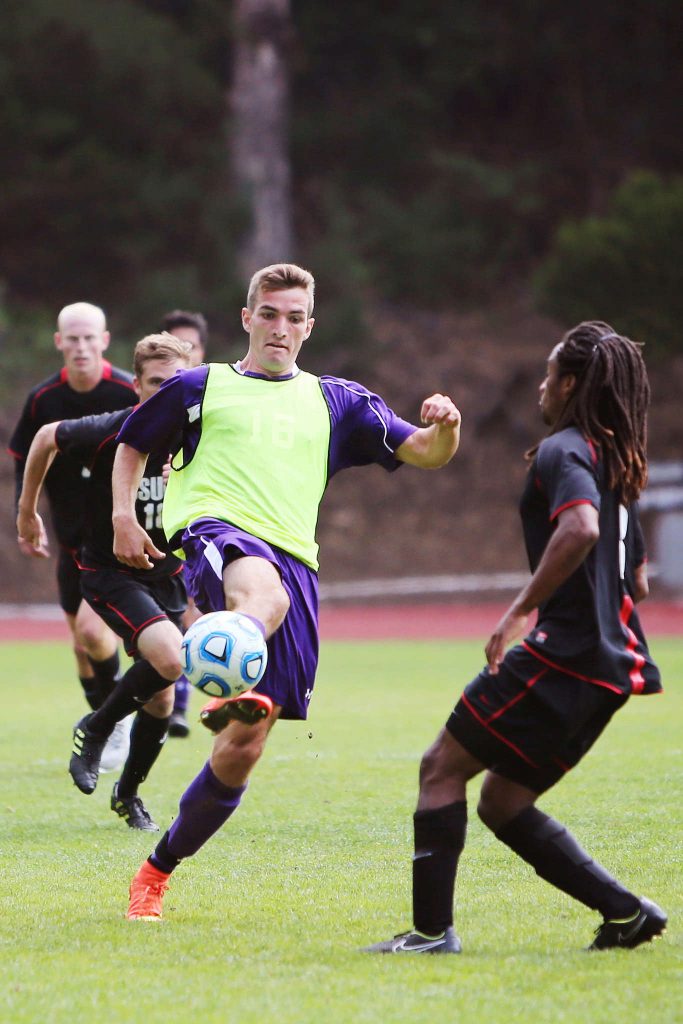 SF State Gator forward Cameron DeJong, # 16, volleys the ball out of the air away from advancing Cal State East Bay players, Kellen Crow, #15, and Arthur Ethel, #3, at Cox Stadium on Sunday, Sept. 28, 2014.
