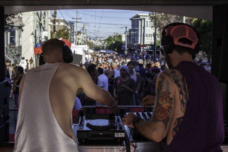 Partners David Sternesky and Matthew Dos Santos, better known as music duo Two Dudes in Love, co-DJ a set on the 18th Street stage as fair attendees dance during the Castro Street Fair in San Francisco Sunday, Oct. 5, 2014. Frank Ladra / Xpress.