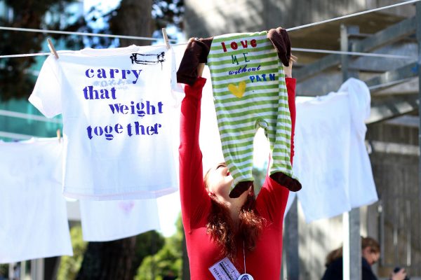 Kandice Khopp hangs a onesie during the Clothesline Project at SF State Monday, Oct. 27, 2014. Henry Perez/Xpress.