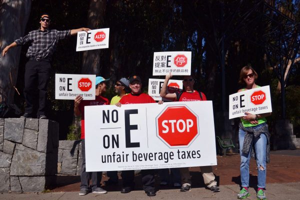 Paid volunteers for the No-on-E campaign hold signs up on the corner of Sloat Boulevard and 19th Avenue, opposing the soda tax being voted on that day Tuesday, Nov. 4, 2014. Helen Tinna/Xpress.