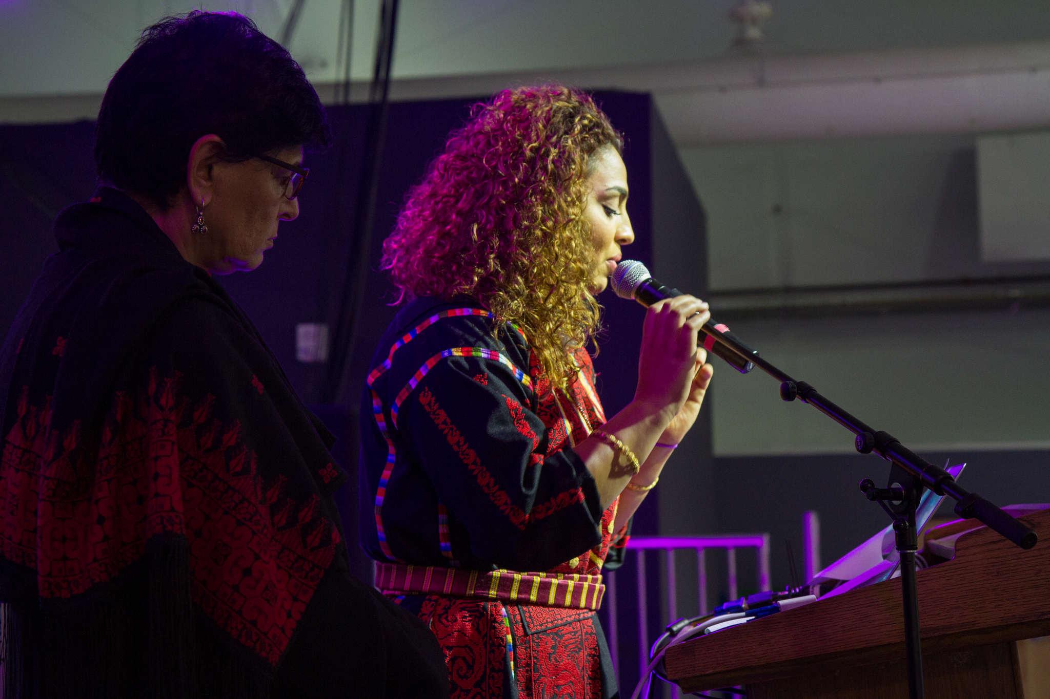 Professor Rabab Abdulhadi stands beside GUPS President Lubna Morrar as she recites a poem by Samih Al-Qassem, at the 7th Annual Edward Said Mural Celebration in the SF State Student Event Center on Wednesday, Nov. 5, 2014.