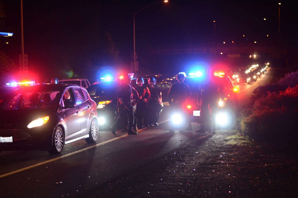Police survey the scene as protestors shut down both directions of traffic on the I-980 freeway in Oakland, Calif. Tuesday, Nov. 25, 2014. Crowds have gathered for two days in a row after word that Ferguson police officer Darren Wilson would not be charged for killing teenager Michael Brown. Peter Snarr/Xpress.