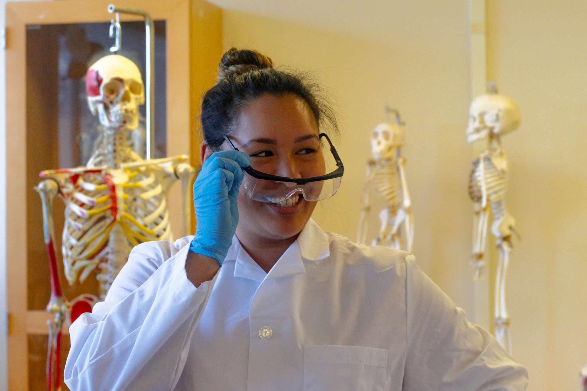 SF State senior Rachel Morales puts on her glasses in the dry lab as she prepares to dissect cadavers for her human anatomy class Thursday, March 5. 2015. (Angelica Ekeke / Xpress)