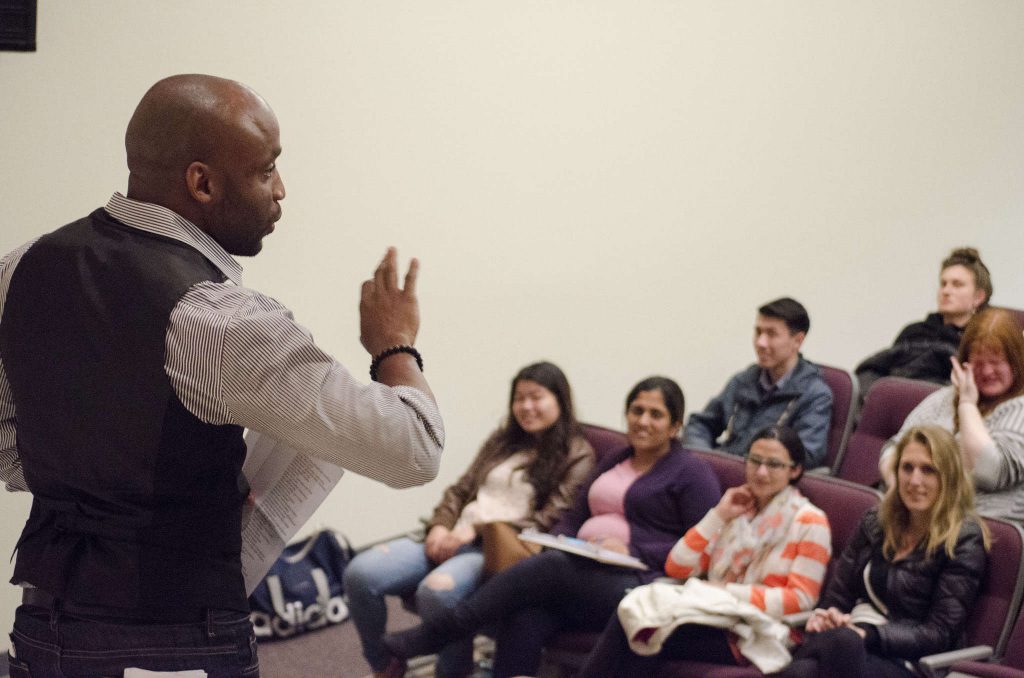 Javon Johnson, an assistant professor of Performance and Communication studies at SF State, recites poetry to a group of students in the Humanities Auditorium Friday, Feb. 26. (Hyunha Kim / Xpress)