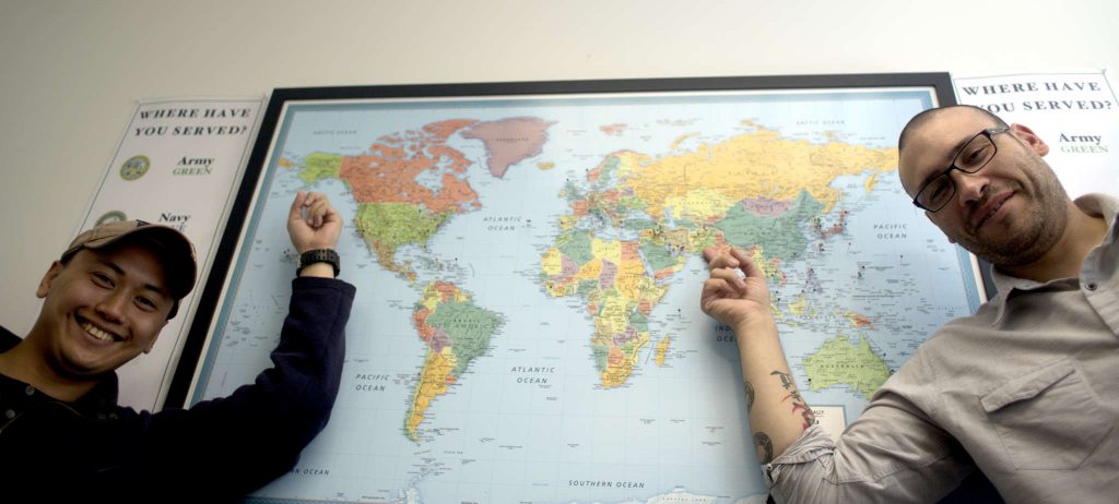 JP Sacramento, right, electrical engineering major and Veteran formally stationed in Alaska and Anthony Rueda, graduate student and Veteran formally stationed in Fort Bliss, Texas point to their stations locations on a map in the  Veterans Services Center at SF State Monday March 2. (Emma Chiang / Xpress)
