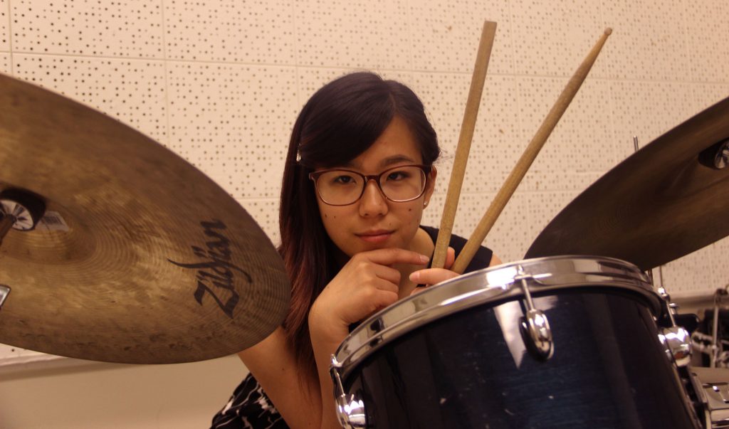 Jazz drummer Lilian Wu sits with her drums in the Creative Art building for a portrait Thursday, April 16. (Angelica Williams / Xpress)