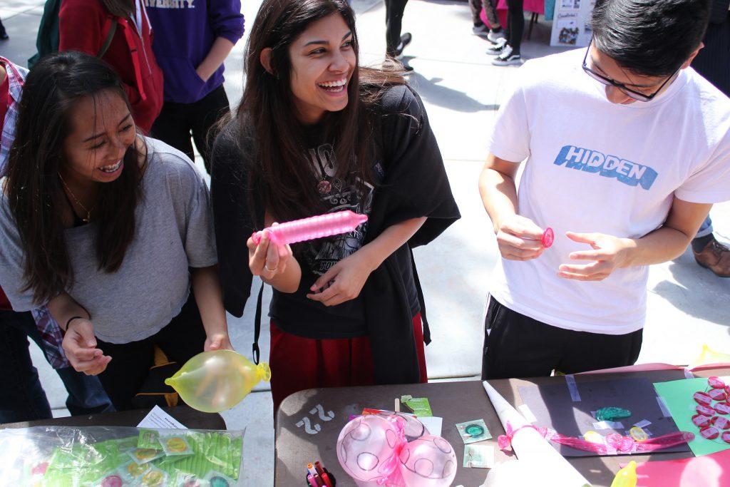 (from left to right) Leilanie Dacuycuy, Jasmine Calix and Logan Limm inflate condoms to make balloon art during the Multi-cultural Aids Awareness Day in the quad Thursday, April 9. (Drake Newkirk / Xpress)