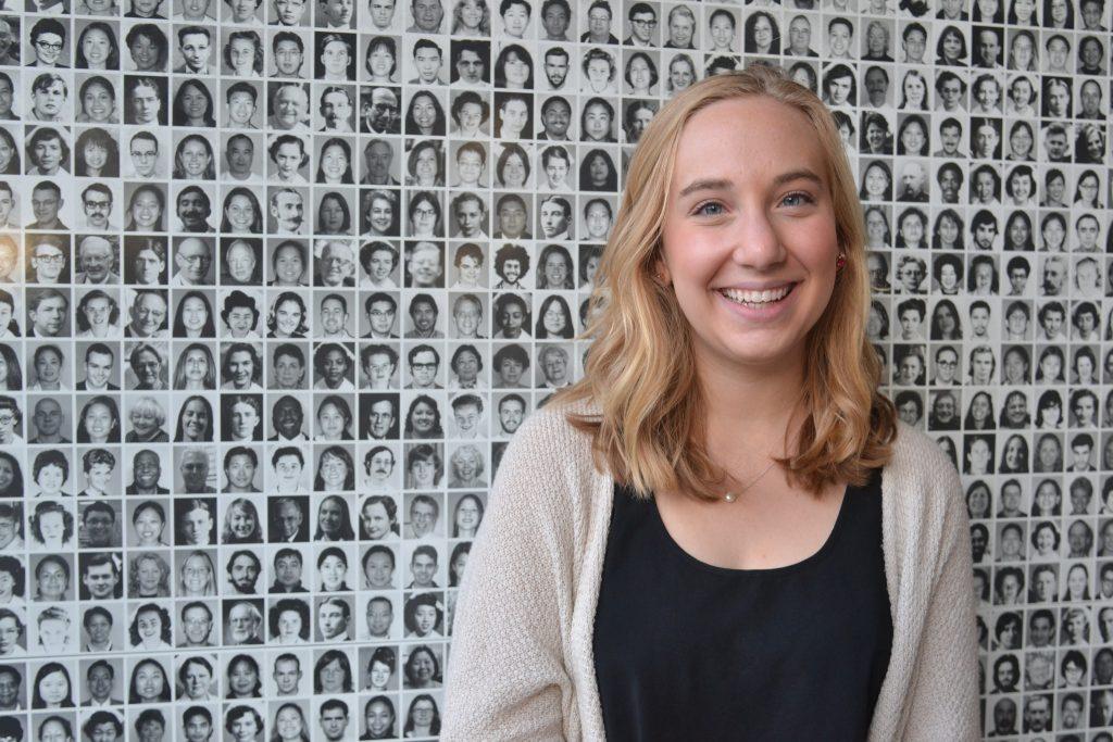 SF State alumna Molly Diedrich poses for a
portrait in front of a wall of former students, faculty and staff Aat UCSF Medical Center Tuesday, April 14. (Helen Tinna / Xpress)