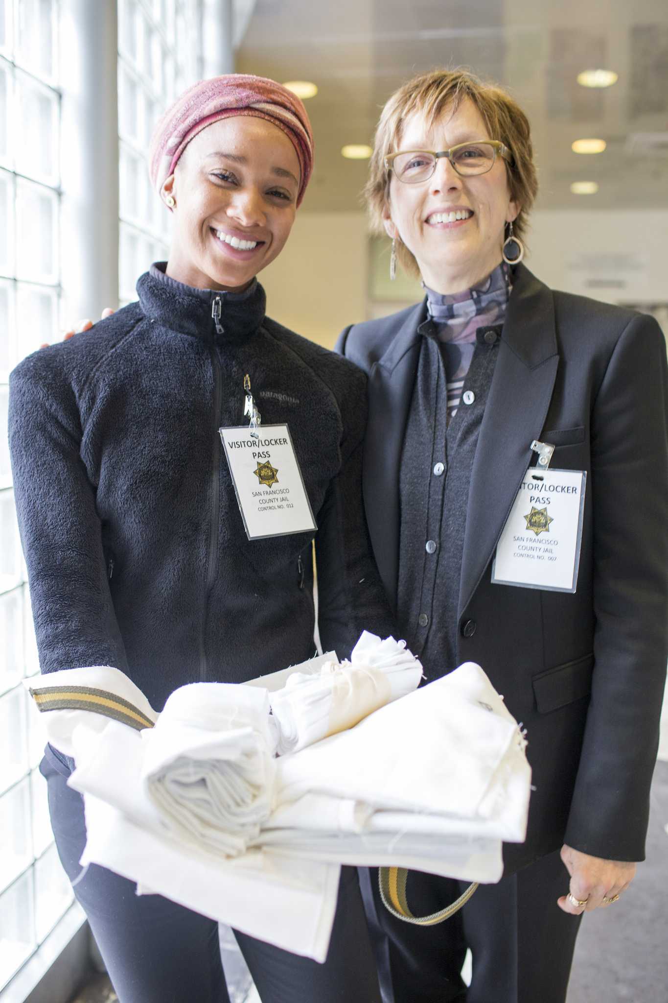 Dr. Connie Ulasewicz and Keno Greene, one of the five graduate students in a Social Entrepreneurship class, present fabric to student inmates who will use to make tote bags at the San Francisco County Jail Mon. May 4, 2015. (Martin Bustamante / Xpress)