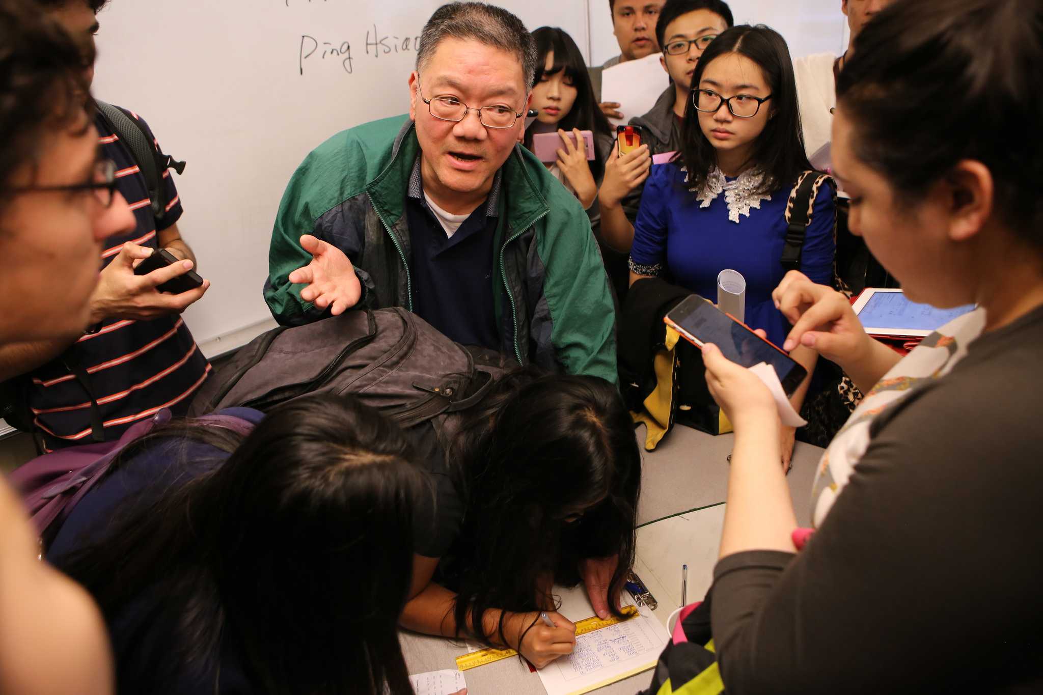 Finance Department Chair Ping Hsiao takes down the names of students with prerequisites who were waiting to be added to a new Finance 350 section in the Business building at San Francisco State University on Thursday August 27, 2015. (Joel Angel Juárez /  Xpress)