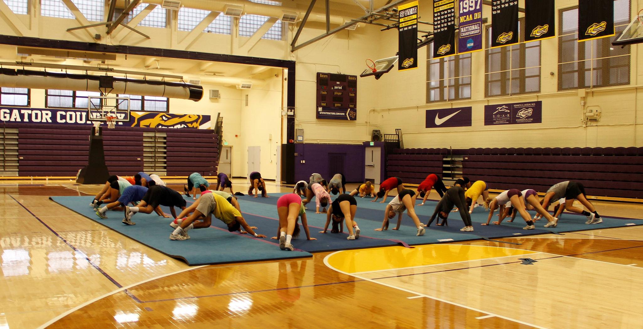 SF State cheerleaders stretch out their legs before practicing in the main gym at SF State Friday Sept. 4, 2015. (Imani Miller/Xpress)