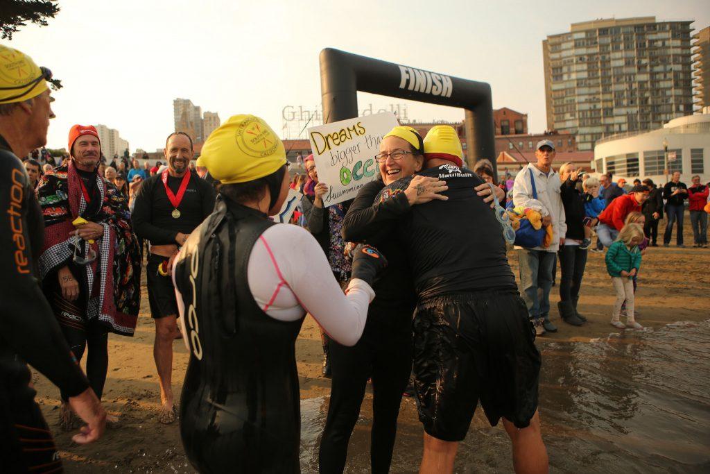 Nancy Jodaitis (left), an AB 540 financial aid counselor at SF State, hugs SF State alumni Marcos Tapia (right) after swimming to shore during the Alcatraz Invitational on Sunday, Sept. 13, 2015 in San Francisco, Calif. (Joel Angel Juárez /  Xpress)
