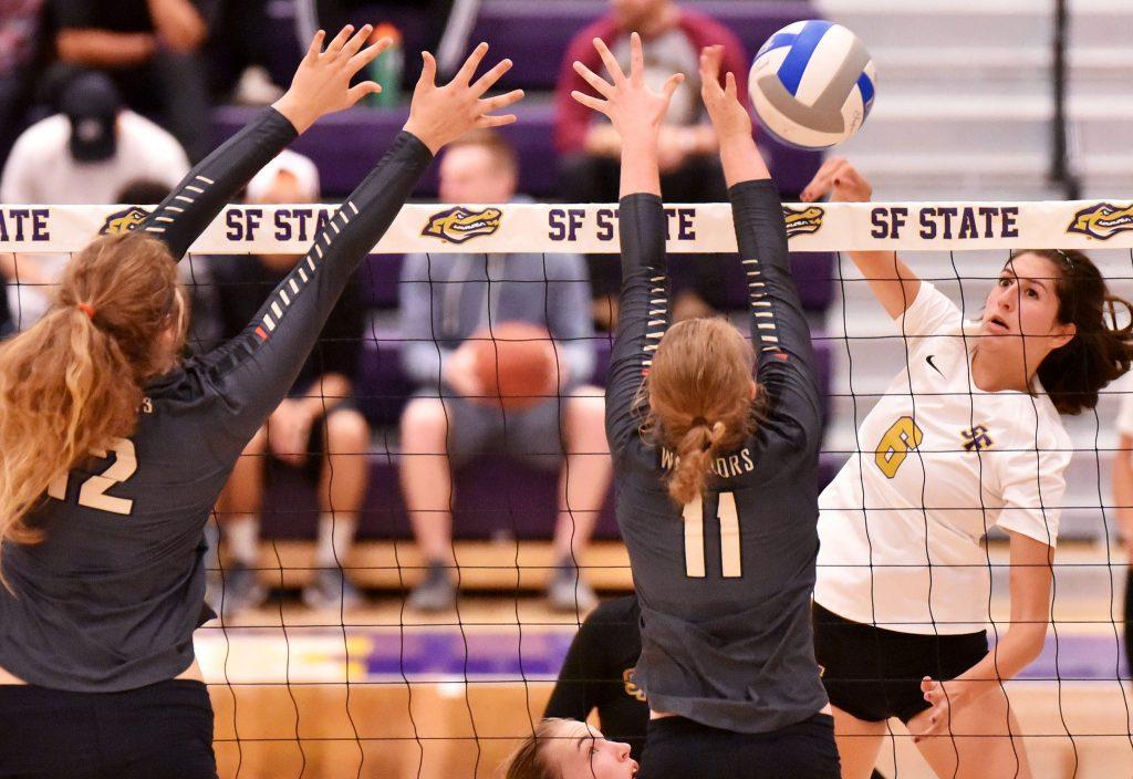 Jaclyn Clark (6), outside hitter for SF State Gators, spikes the ball against Stanislaus State Warriors middle blocker 
Taylor Massengale (12), and setter Maddi Seidl (11), at the Swamp at SF State Tuesday, Sept. 29. SF Gators lost 1-3. (Qing Huang / Xpress)