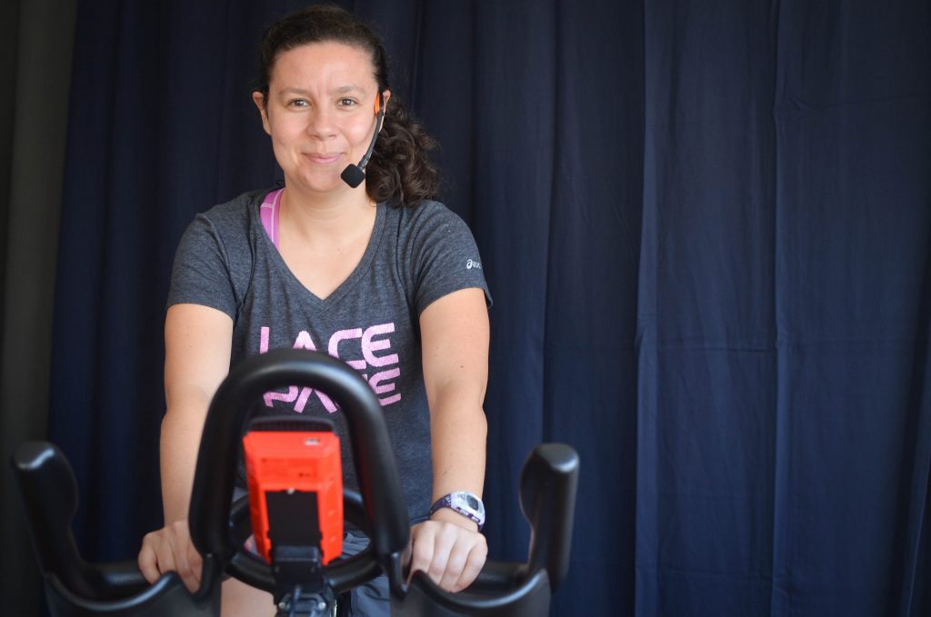 Tia Kilpatrick, owner and lead instructor of Versa Indoor Cycling & Fitness, poses for a portrait on an exercise bike in the fitness studio at Versa Indoor Cycling & Fitness in San Francisco, Calif. Thursday, Oct. 22. (Melissa Minton / Xpress)