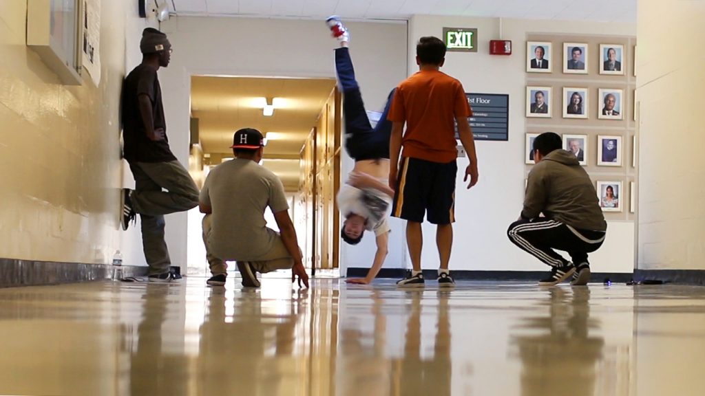 Members of the Hip Hop State of Mind club watch Sean Morales, English major, make a hand stand in the Gymnasium hallway Tuesday, Nov. 3, 2015. (Screenshot by Creo Noveno / Xpress)
