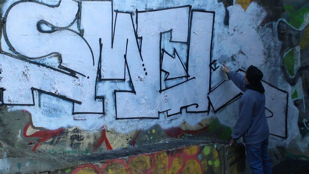 Smel tags his tag name on a wall in Ocean Beach Saturday, Nov. 28, 2015 (Screenshot by Carlos Guerrero and Cody Wright / Xpress)