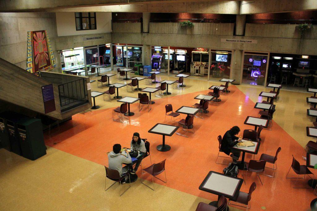 Students sit and eat in the near empty basement of the Cesar Chavez Student Center at SF State on Tuesday, Jan. 26, 2016.
