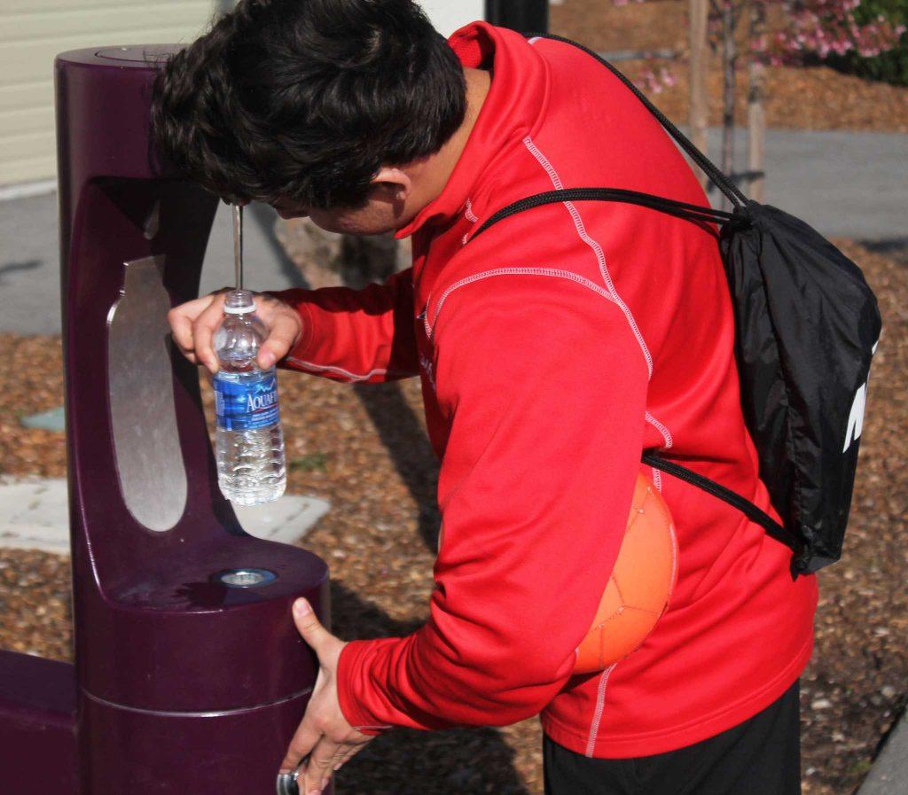 Alexander Garduna, refilling his water at the new recycle water distribution machines. SF State, near Village, San Francisco, Calif. Thursday. Feb 19, 2016. Gardena was refilling his water bottle at the new fountain, he was in a hurry to have an interview with his professor. (Pablo Caballero / Xpress)