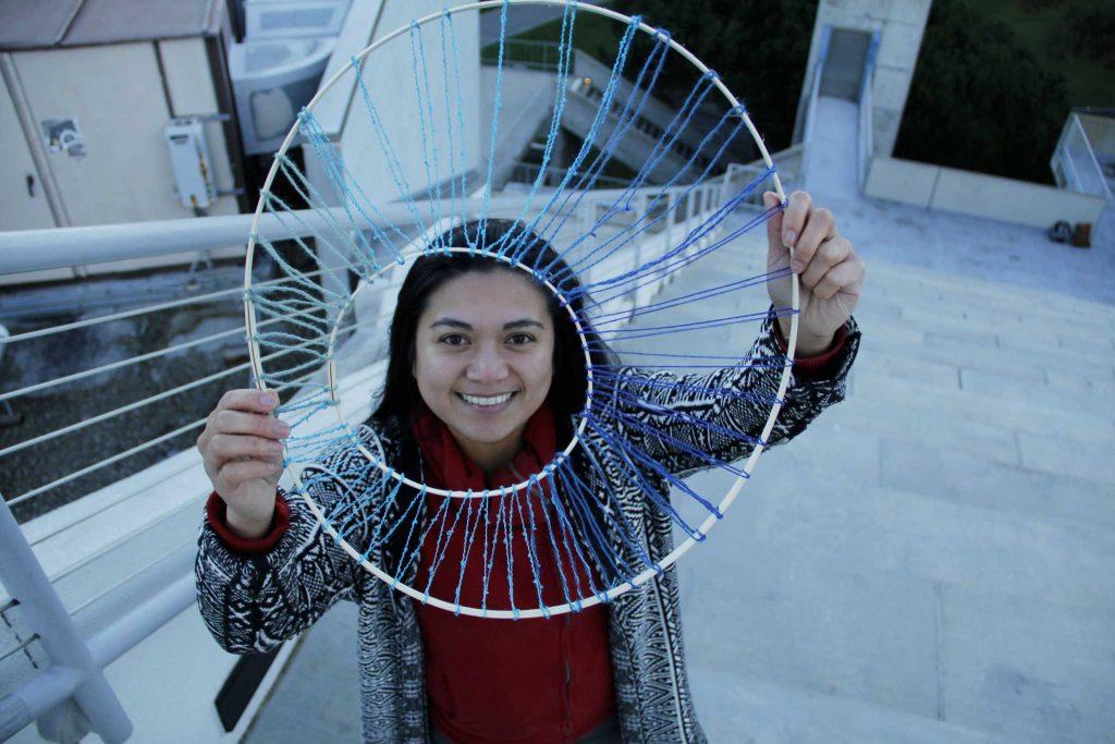 SF State alumna Mona Marcos poses with a piece from the upcoming Resiliencies: Poetics of Filipino Diaspora exhibit on top of the Cesar Chavez Student Center, Tuesday, Feb. 2, 2016. (Imani Miller/ Xpress)