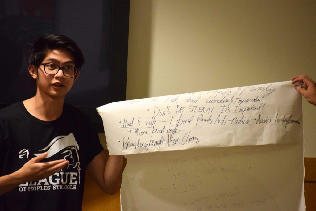 SF State student Raymond Jegillos holds up a poster with important topics put together by members of the League of Filipino Students during their peace talk forum in the Richard Oaks Multicultural Center in the Cesar Chavez Student Center on Thursday, October 20, 2016. 