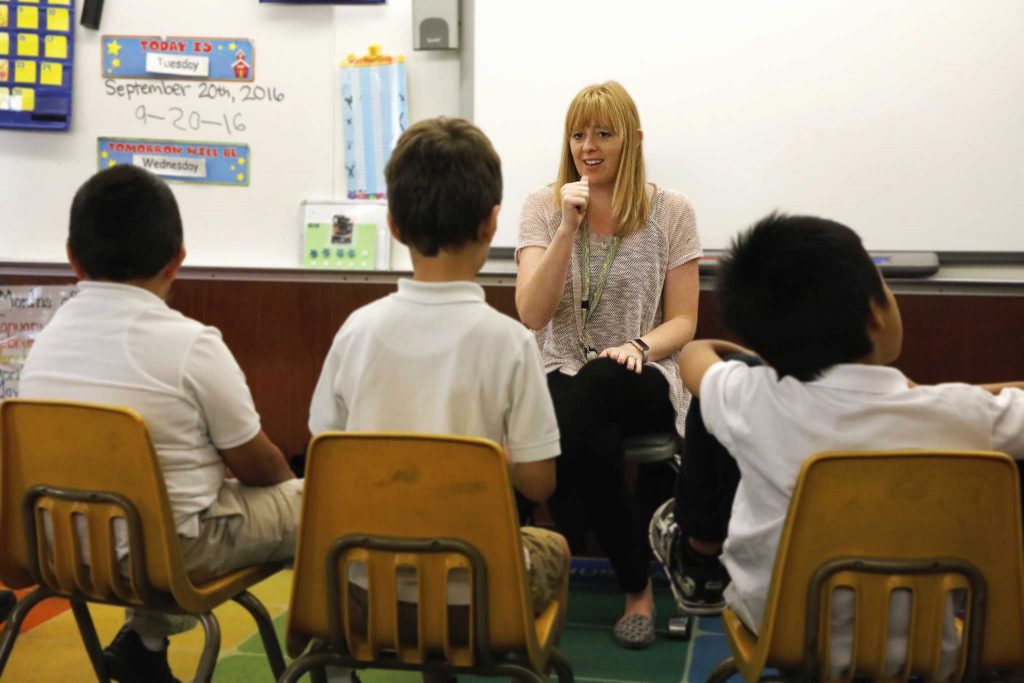 Kayla Kenton, a graduate of SF States Moderate Severe Special Education program, uses sign language to communicate with children with autism during their morning sing-along at Junipero Serra Elementary School in Daly City, Calif. on Tuesday, Sept. 20, 2016.