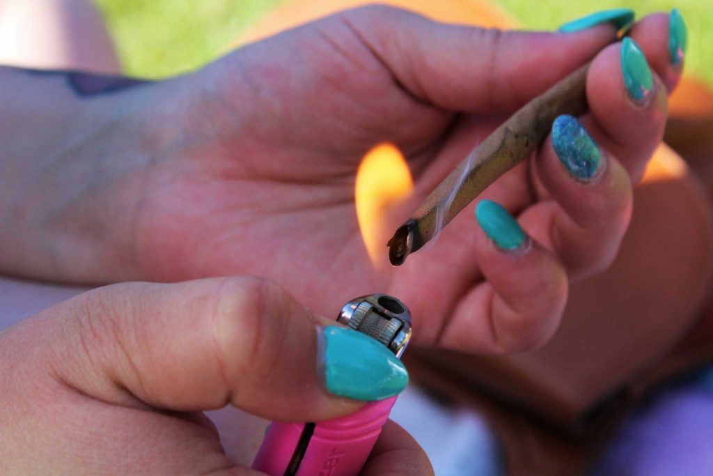 Amanda Clanton, 24, sparks up a marijuana cigarette in Golden Gate Park on April 4, 2015 in San Francisco, Calif. Photo by Alina Castillo.