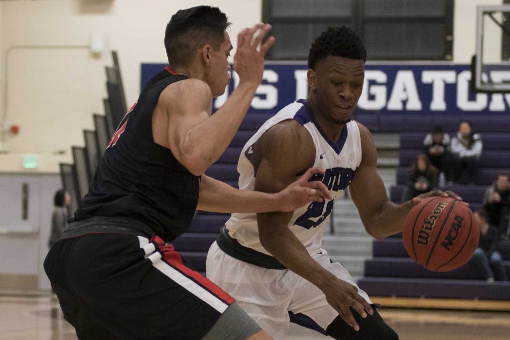 SF State Gators sophomore guard Chiefy Ugbaja (23) drives to the basket against Pioneers senior forward Micah Dunhour (11) during the Gators 80-65 win over Cal State East Bay at the Swamp on Saturday, Dec. 3, 2016.