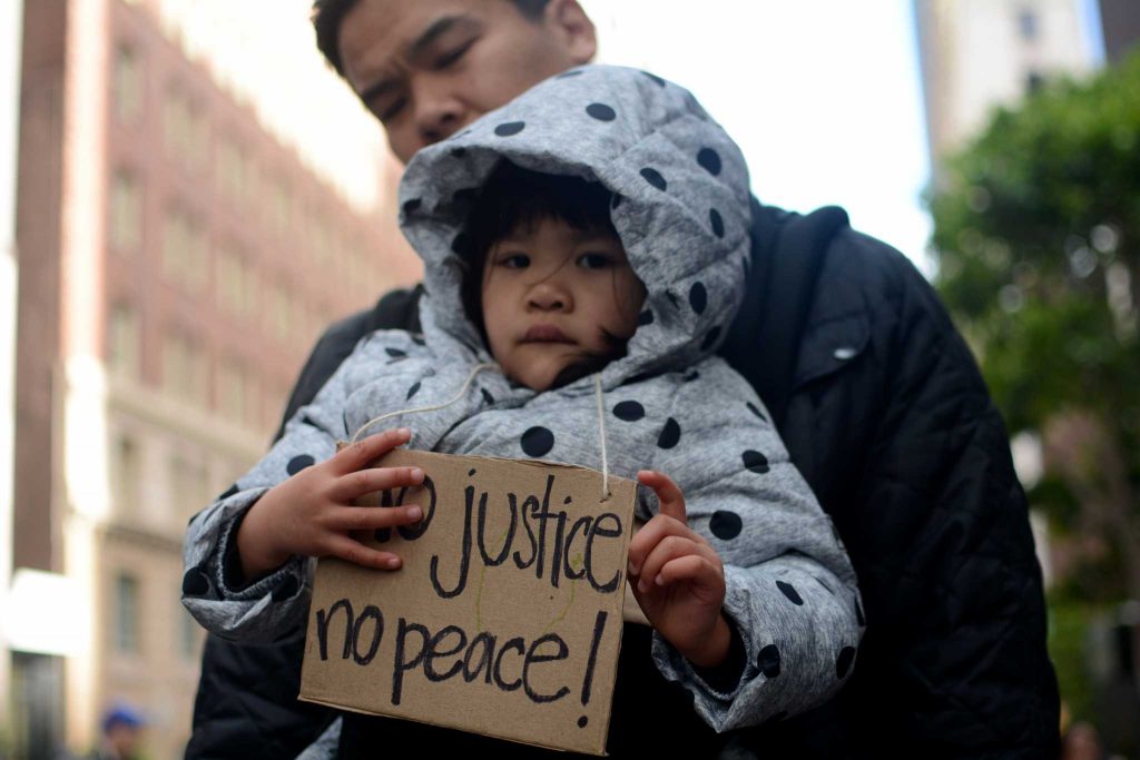 A young child holds a sign that reads No justice, no peace! during the Bay Area Resist Trump Morning March and Rally in San Francisco on Friday, January 20, 2017. (Photo: Aaron Levy-Wolins/Xpress)