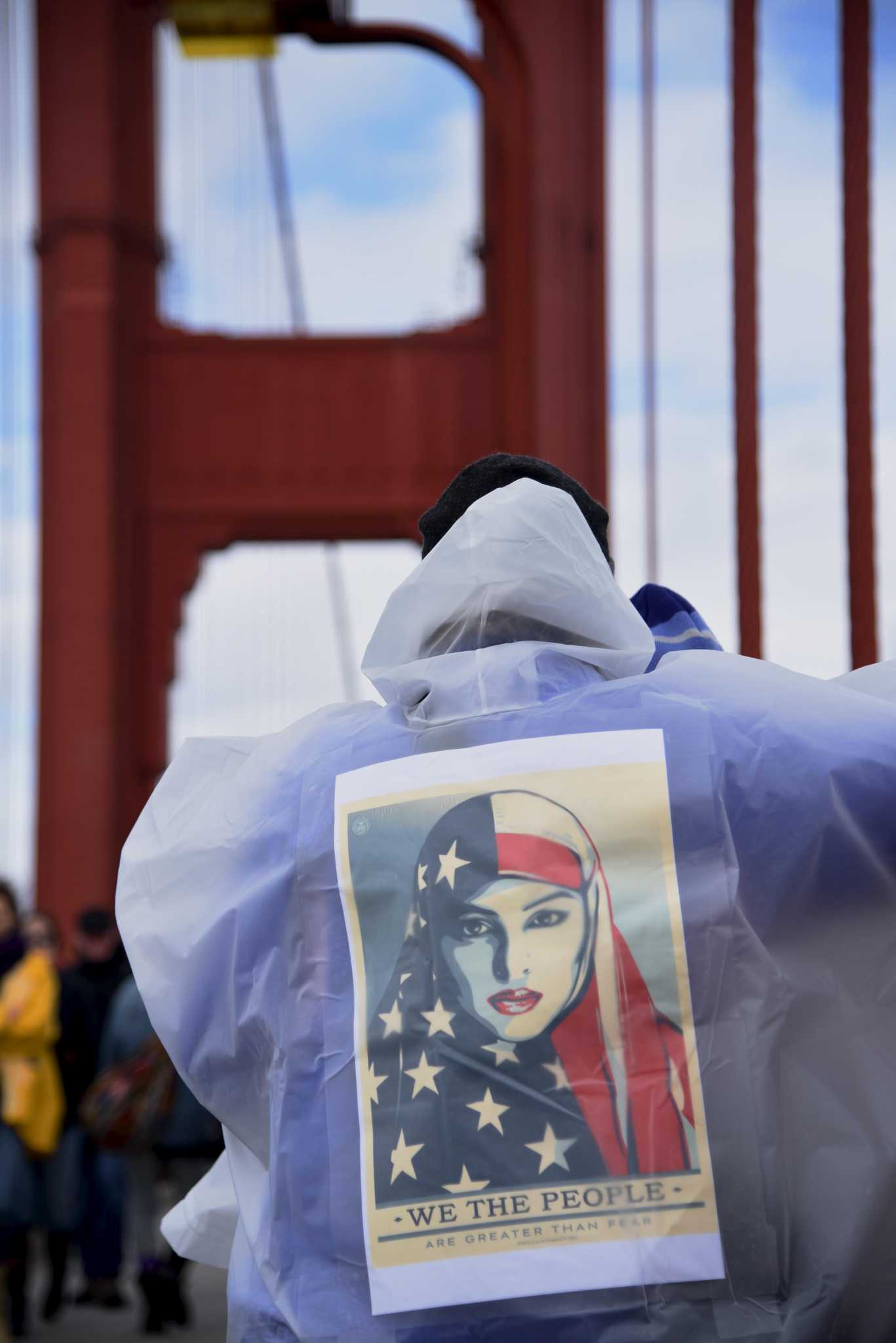 Liza Loeffler wears Shepard Faireys inauguration poster on her back at the Golden Gate Bridge in San Francisco, Calif., on Friday, January 20, 2017. I want to encourage people to print and download them for the Womens March tomorrow in Oakland, she said. (Lauren Hanussak/Xpress)