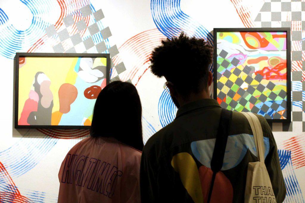 Michael Covington, 28, and girlfriend Vanessa, 24, admire the works of art Covington produced for the showing of Shakin System in the Cezar Chavez Student Center at SF State on Thursday, February 16, 2017 (Alina Castillo / Xpress).