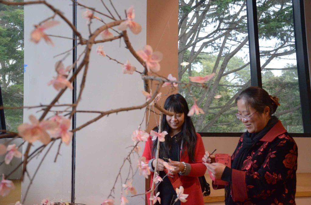 Chinese language students Yafang He, and Liyao Zhu hang their wishes on a wishing tree at the Chinese New Year celebration held on Feb. 3, 2017 at Jack Adams Hall. (Christianna Fjelstad/Xpress)