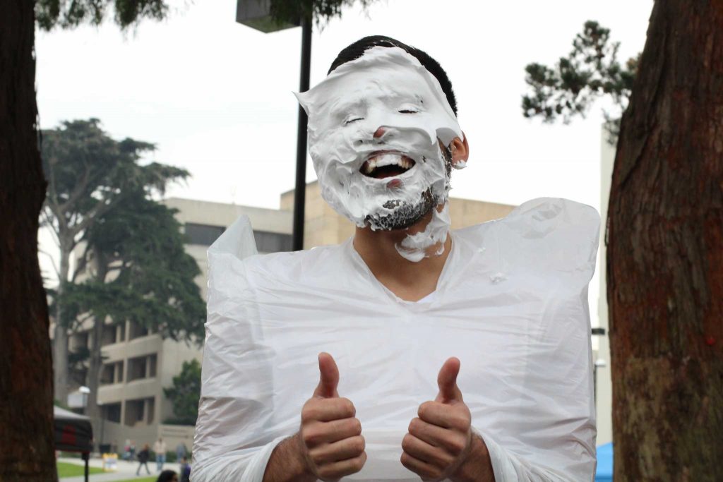 Arturo Dominguez gives two thumbs up after being pied to raise awareness for the Hermanos Unidos de SFSU organization in front of the Cesar Chavez building on February 1, 2017 in San Francisco, Calif. (Alina Castillo/Xpress)