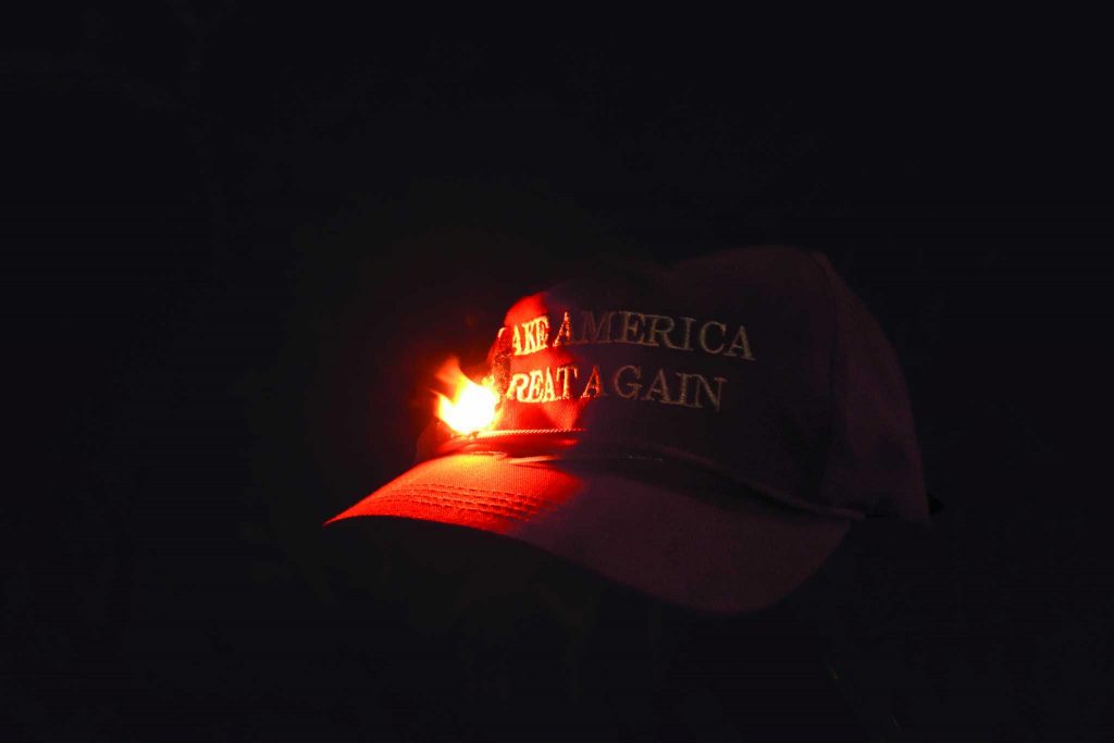 A Trump Supporters hat is set on fire at a riot protesting controversial speaker Milo Yiannopoulous, who was scheduled to speak Feb. 1, 2017. The event was canceled due to violent riots (Tate Drunker/Xpress).
