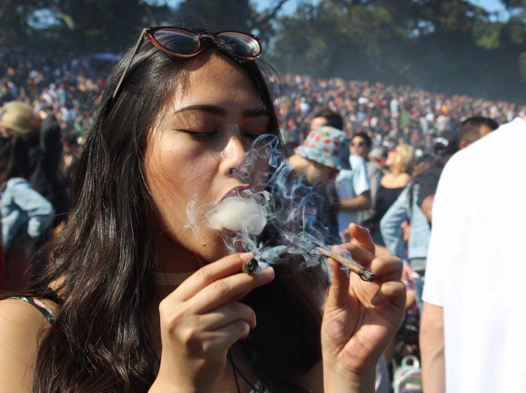 Lealana Newman hits two blunts at exactly 4:20 p.m. at the city-permitted 420 celebration at Hippie Hill in San Francisco, Calif. on April 20, 2017 (Xpress/MJ Ongoy).
