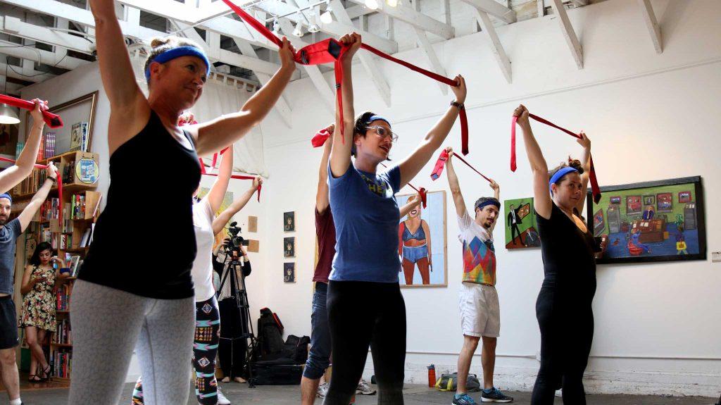 Anti Trump Aerobic class participants stretching with ties at Alley Cat Bookstore in SF on April.30, 2017 (Kyler Knox/Xpress)