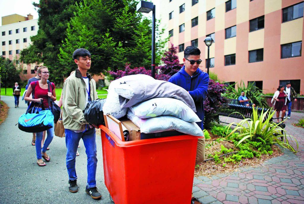 People move a cart into Mary Park Hall during freshmen move-in day at San Francisco State on Saturday, August 19, 2017. (Mira Laing/Golden Gate Xpress)