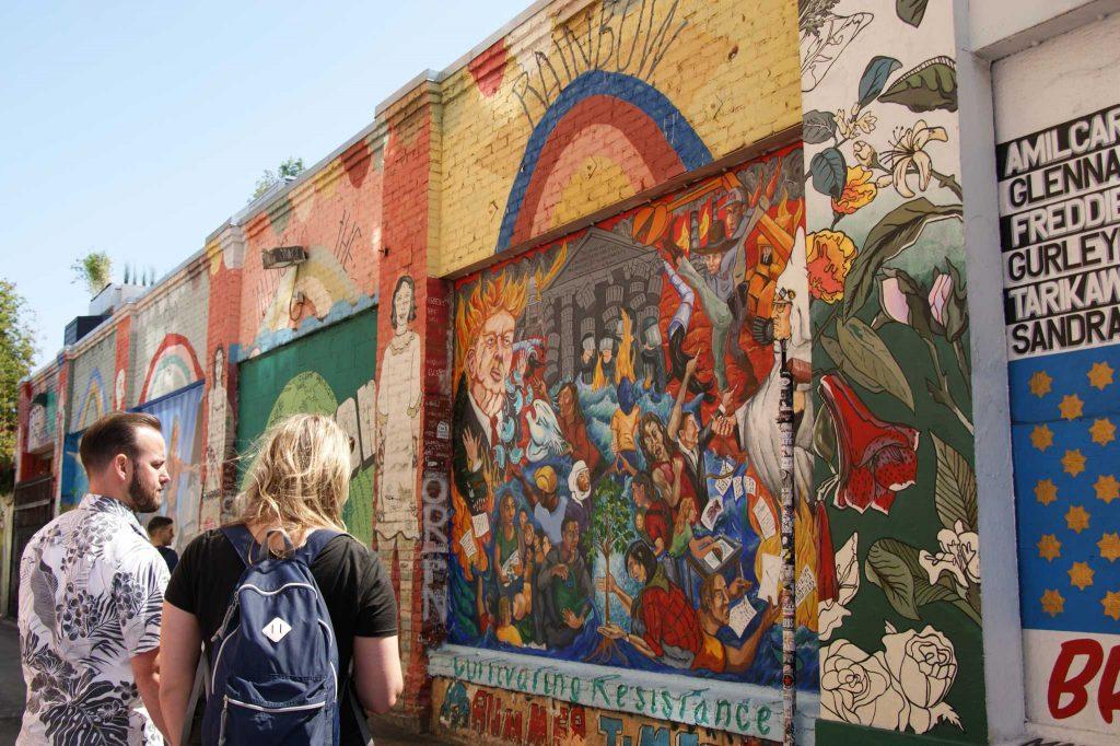 People talk in front of a mural titled Cultivation Resistance at Clarion Alley in San Francisco on Friday, September 15, 2017. (Aya Yoshida/Golden Gate Xpress)