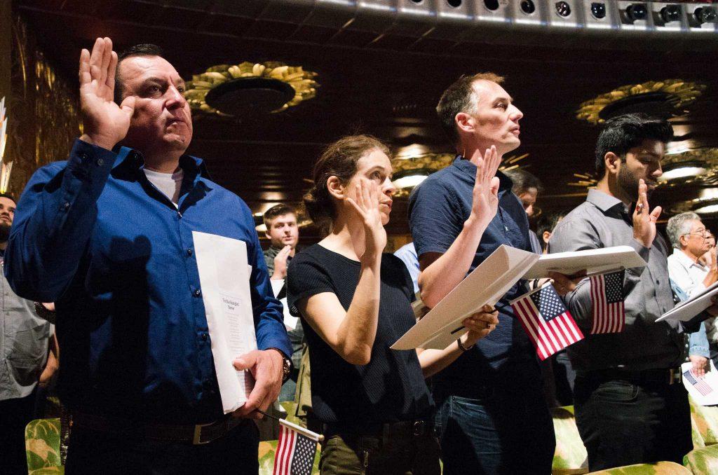New citizens take an oath of allegiance during Register New Citizens to Vote hosted by Democracy Action at Paramount Theatre in Oakland on Thursday, September 7, 2017. (Richard Lomibao/Golden Gate Xpress)