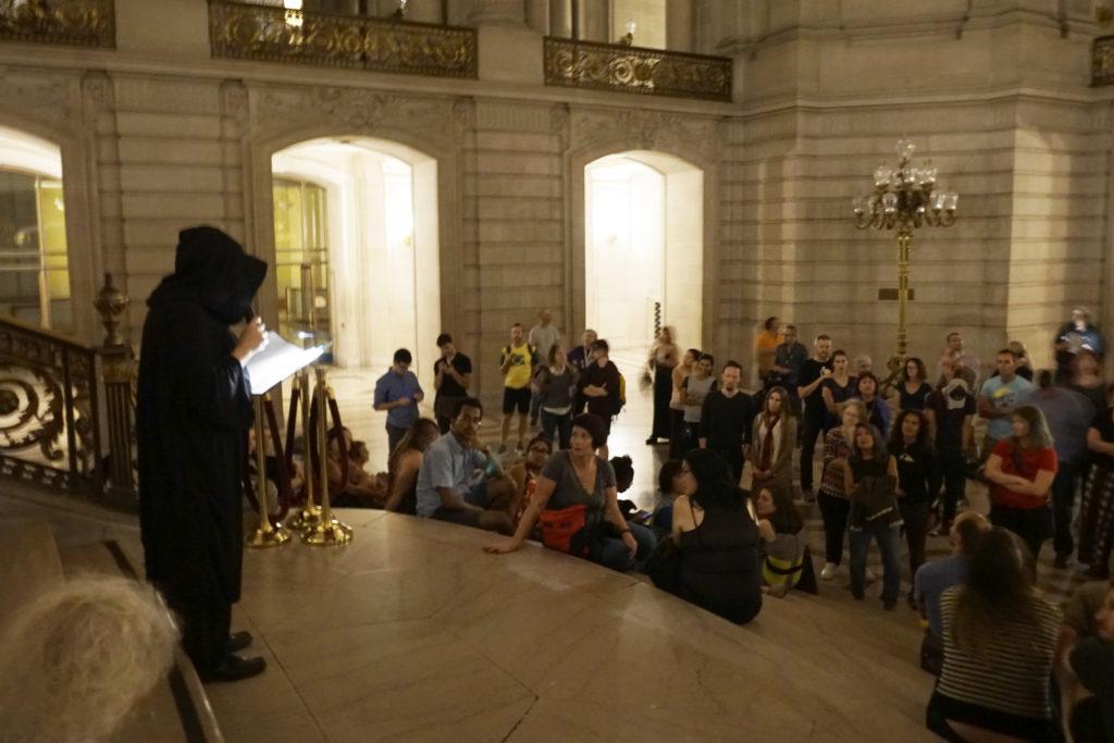 A curator reads ghost encounter stories to a crowd at the Ghost Walk Tour at San Francisco’s City Hall on Thursday, Oct. 26, 2017. (Diego Aguilar/Golden Gate Xpress)